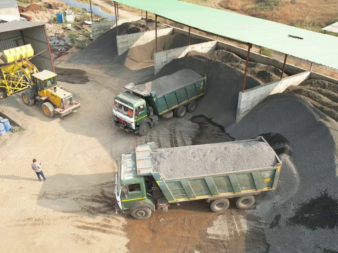The wheel loader at the aggregate batcher, with tippers in the roofed bays